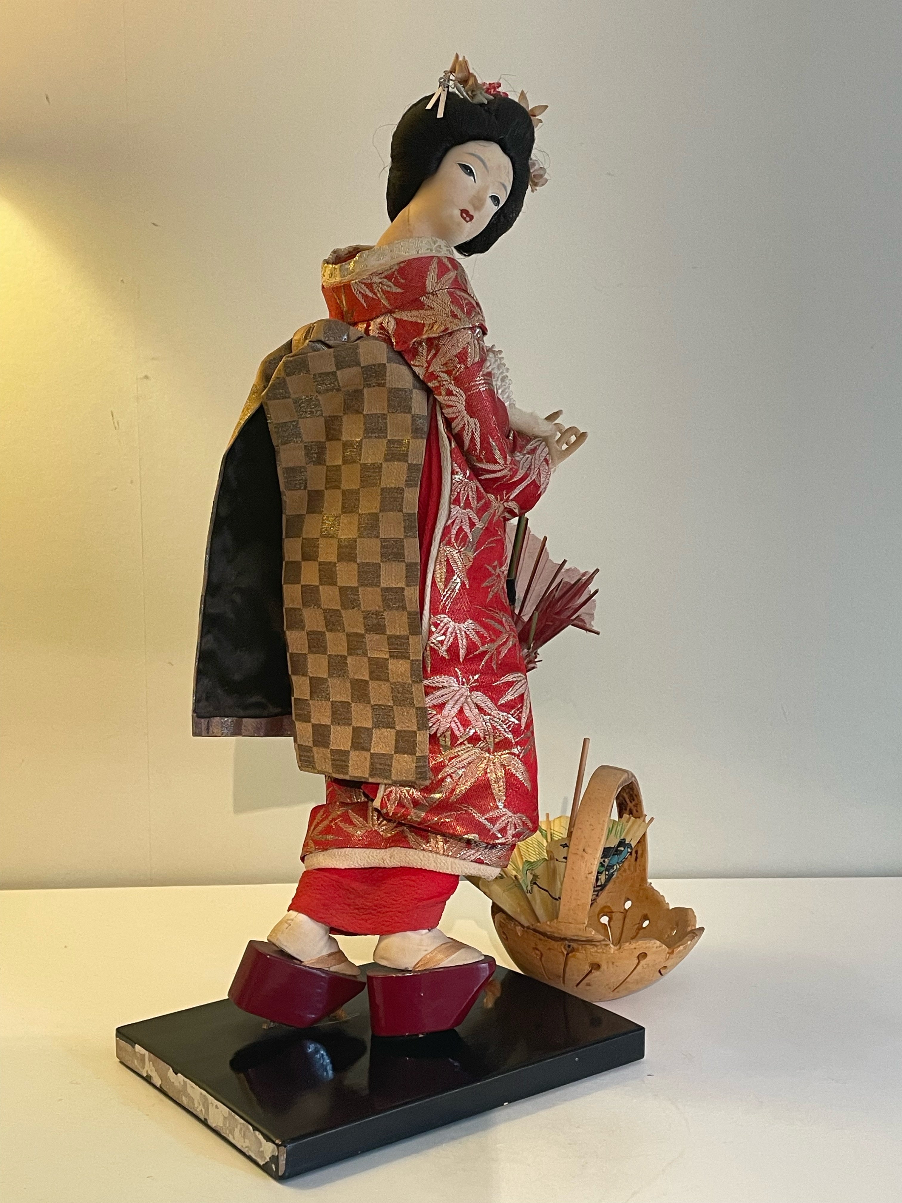 Vacker Geisha med autentisk kulturell kimono med medföljande vagn i mässing.