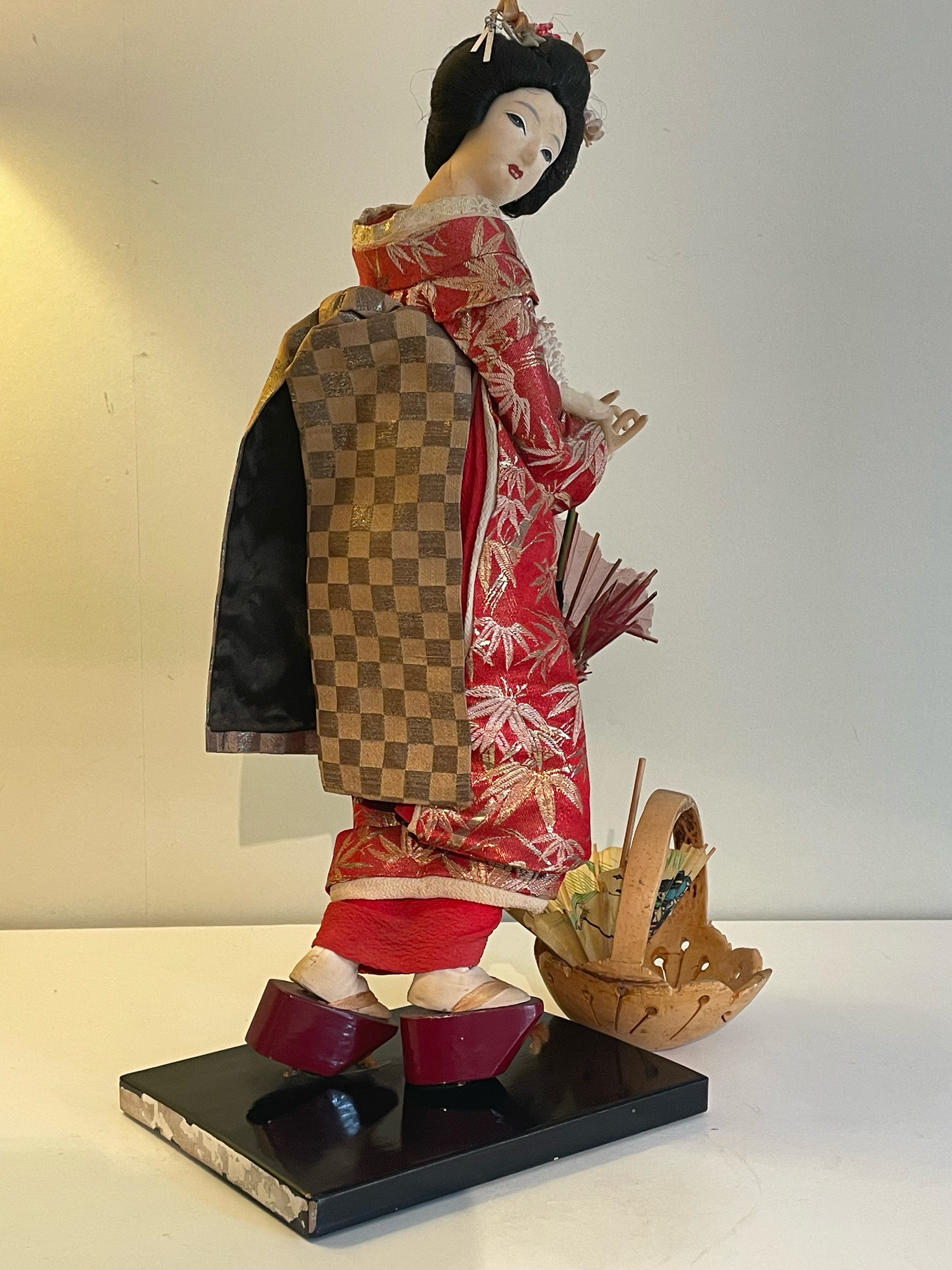 Vacker Geisha med autentisk kulturell kimono med medföljande vagn i mässing.